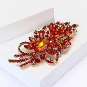 Detailansicht der Vintage-Blumenbrosche mit orangem Hauptstein und roten Straßsteinen