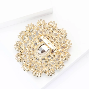 Detail view of large alloy glass brooch back with intricate gold-plated hollow metalwork