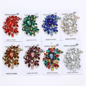 Close-up of alloy flower brooches featuring large teardrop crystals in eight vibrant colors