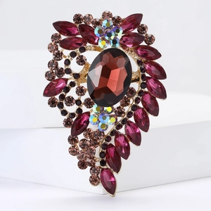 Macro detail of luxury alloy brooch with burgundy rhinestones and faceted amber gemstone