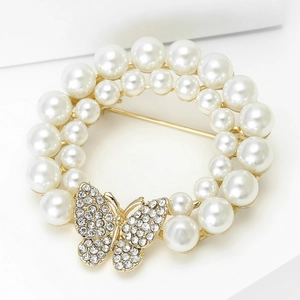 Détail macro d'une broche couronne de perles élégante avec accent papillon en strass