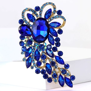 Macro shot of luxury deep blue glass brooch with crystal stones and golden base finish