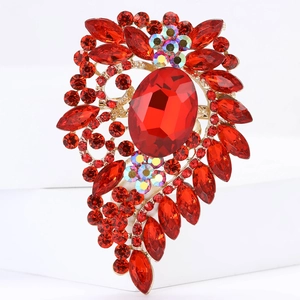 Close-up of a large vintage alloy brooch with red faceted gemstones and gold-tone finish