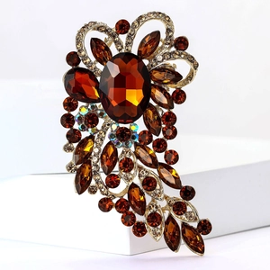 Close-up of vintage gold alloy brooch with amber glass stones and aurora crystals