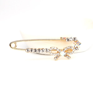 Broche épingle dorée élégante ornée de cristaux et d'un nœud délicat en strass
