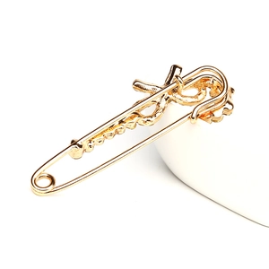 Broche épingle de sûreté dorée élégante avec design ondulé et cristaux pour costume