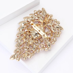 Detail view of gold alloy vintage brooch with hollow carving and safe pin closure