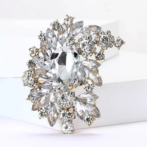 Detailed close-up of a luxury pear-shaped crystal brooch with gold alloy setting