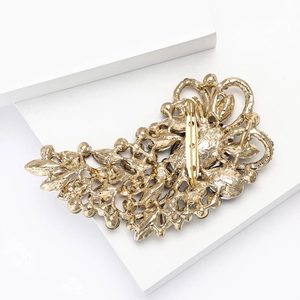 Detailed back view of large alloy brooch showing rotary safety pin and hollow engraving