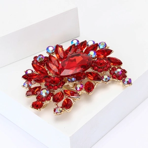 Vintage gold alloy brooch with large red crystals and iridescent rhinestones in floral shape