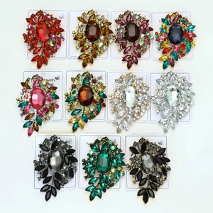 Vista detallada de varios broches de flores vintage con cristales y diamantes de color