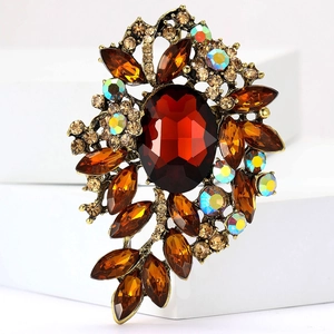 Detalle de broche vintage con gema ovalada roja y cristales de talla marquesa color ámbar