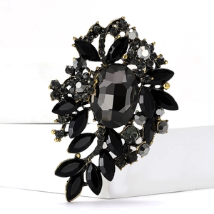 Detalle del broche de flor vintage con cristales facetados negros sobre base dorada