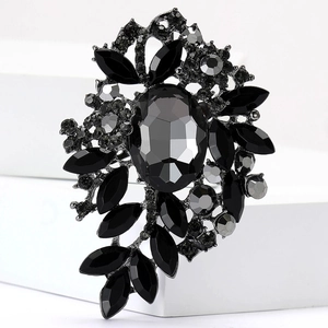 Detalle de broche vintage con gema ovalada negra y diamantes de imitación sobre base negra