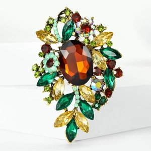 Detalle de un broche floral vintage con una gran piedra de ámbar y cristales de colores