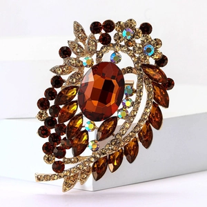 Detailed macro view of vintage gold-tone floral brooch with amber crystals and AB rhinestones