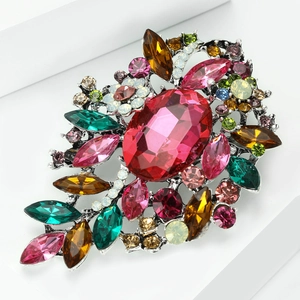 Detalle de broche de lujo con pedrería de colores y cristal tallado sobre aleación