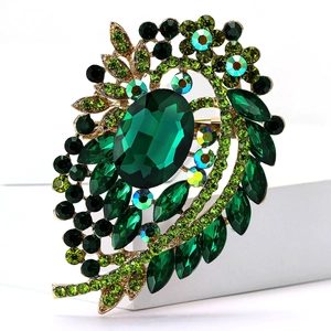 Macro detail of vintage emerald-green glass brooch with crystal petals and gold-tone finish
