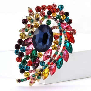 Macro detail of vintage brooch with blue gemstone and multi-colored rhinestones on gold base