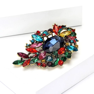 Primer plano de broche vintage de lujo con cristales de colores y piedra de cristal azul
