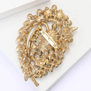Macro detail of the golden alloy brooch back showing the secure pin fastener and glass gems