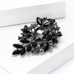 Detalle de broche vintage con cristal gris y diamantes de imitación negros en base