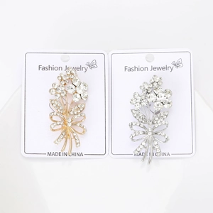 Detail of elegant gold and silver floral brooches with sparkling rhinestones on cards