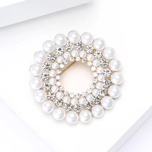 Détail de la broche couronne élégante avec perles blanches et cristaux sur alliage doré