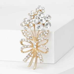 Detailed close-up of sparkling bouquet brooch with rhinestones and golden bow detail