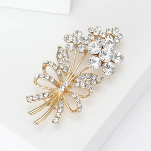 Close-up of sparkling floral bouquet brooch with gold base and white rhinestones