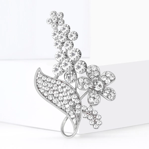 Eleganter versilberter Blumenanstecker mit weißen Strasssteinen und hohlen Blättern