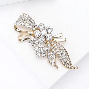 Détail d'une broche fleur avec strass clairs sur une base en alliage doré