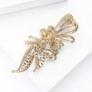 Élégante broche fleur dorée avec noeud en strass et fermeture à épingle sûre