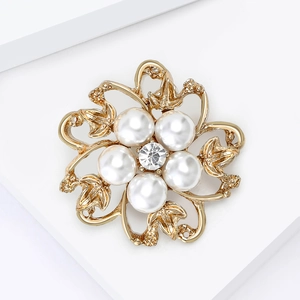 Gros plan détaillé d'une broche fleurie en perles avec zircon central et dorure