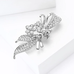 Détail de l'élégante broche fleur argentée ornée de cristaux et de strass scintillants