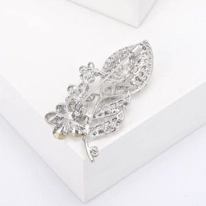 Detailed view of leaf brooch back showing intricate silver hollow-out carving and pin clasp