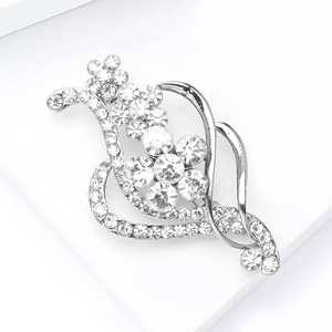 Broche fleur argentée élégante sertie de cristaux brillants sur socle blanc