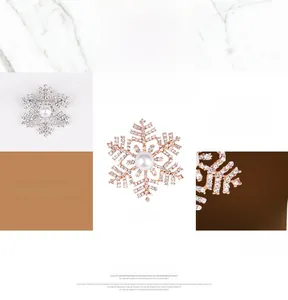 Detailweergave van sneeuwvlokspelden in zilver en roségoud met parels en kristallen
