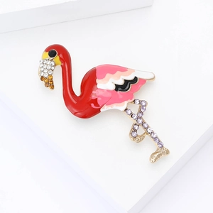 Détail d'une broche flamant rose en émail avec des strass sur un fond blanc minimaliste