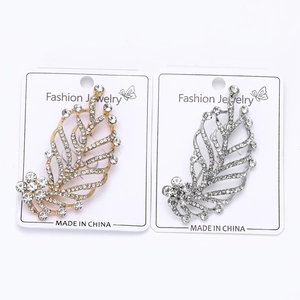 Close-up of gold and silver leaf brooches with sparkling rhinestones on jewelry card