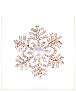 Macro-opname van roségouden sneeuwvlok broche met witte parels en glanzende strasstenen