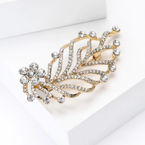 Detailed macro view of an elegant gold leaf brooch featuring brilliant crystal rhinestones