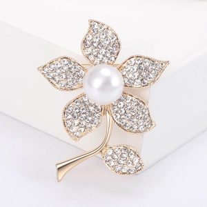 Détails de l'élégante broche florale dorée ornée de perles blanches et de strass étincelants