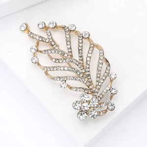 Close-up of gold leaf brooch with micro-paved rhinestones on minimalist white block
