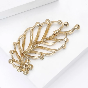Elegant gold leaf-shaped brooch with sparkling rhinestones and metal pin clasp