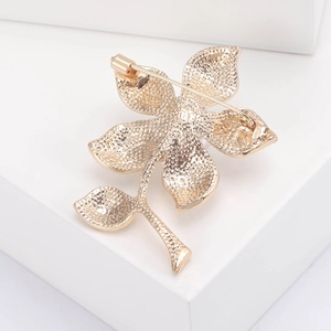 Broche fleurie en perles et strass avec fermoir de sécurité rotatif sur la face arrière