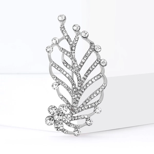 Elegant silver leaf brooch with sparkling rhinestones on a minimalist white background