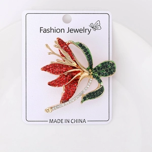 Detailed close-up of a floral daffodil brooch with sparkling red and green rhinestones
