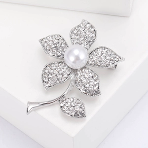 Vue macro d'une broche florale avec une perle centrale et des strass étincelants