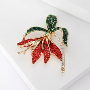 Elegant narcissus flower brooch with red and green rhinestones in a gold finish